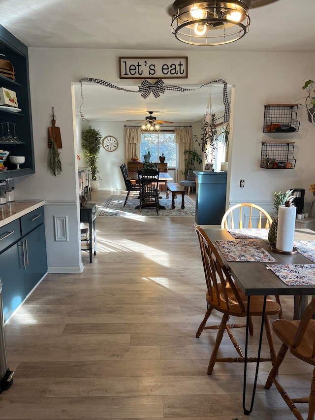 dining space featuring light wood-type flooring and an inviting chandelier