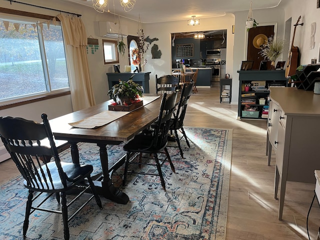 dining space featuring light hardwood / wood-style floors and a wall unit AC