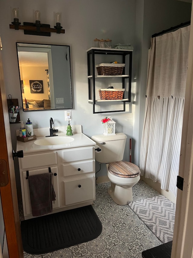 bathroom featuring toilet, tile patterned flooring, and vanity