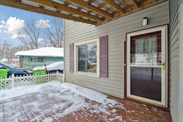 snow covered patio featuring a deck