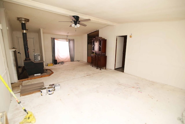 unfurnished living room featuring vaulted ceiling with beams, ceiling fan, concrete flooring, and a wood stove