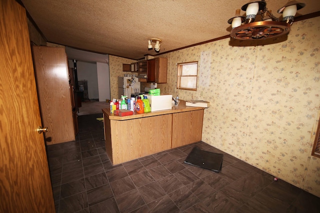 kitchen featuring a textured ceiling, dark tile patterned flooring, kitchen peninsula, a chandelier, and white fridge