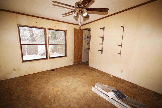 spare room with ceiling fan, ornamental molding, carpet flooring, and a textured ceiling