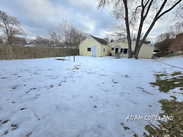 snowy yard with a storage shed