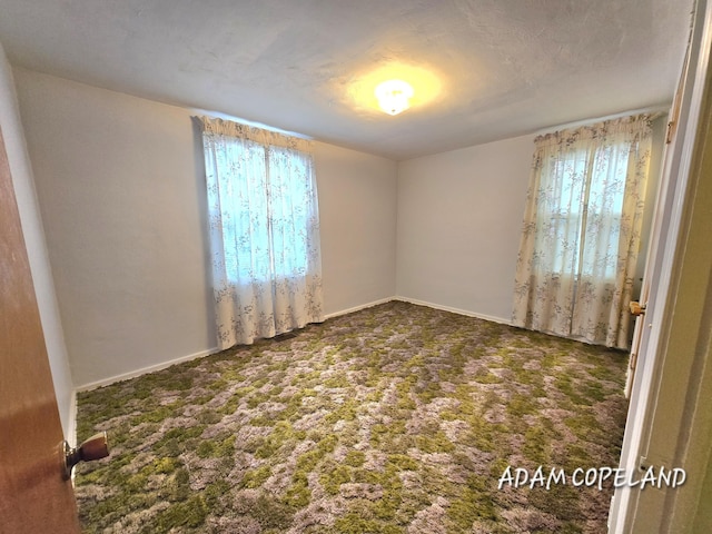 spare room with dark carpet