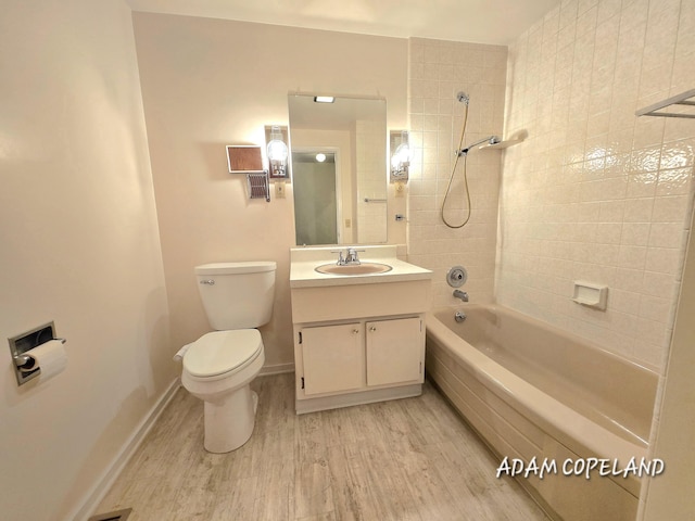 full bathroom featuring vanity, tiled shower / bath, wood-type flooring, and toilet