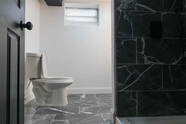 bathroom with toilet and a tile shower