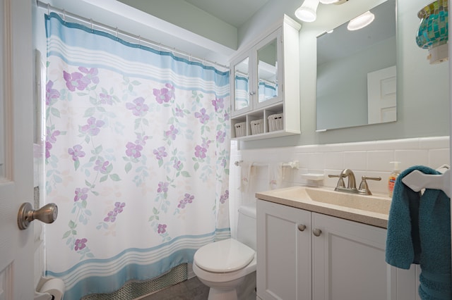 bathroom featuring toilet, tile walls, a shower with shower curtain, and vanity