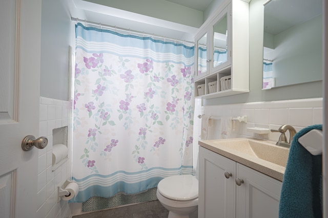 bathroom with curtained shower, vanity, tile walls, and toilet