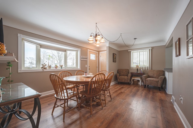 dining space with dark wood-type flooring and a notable chandelier