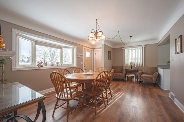 dining room featuring an inviting chandelier and dark wood-type flooring