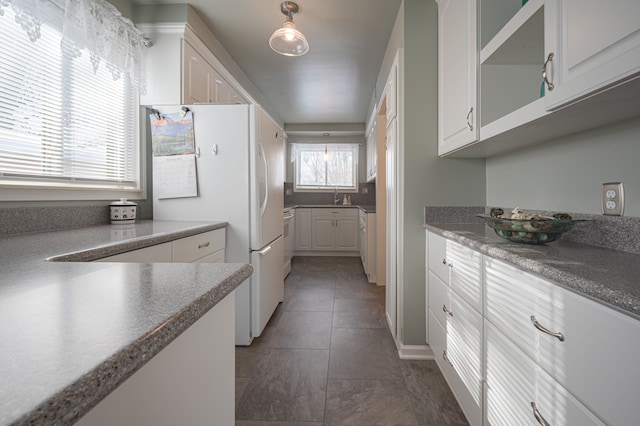 kitchen featuring white fridge, white cabinetry, and dark tile patterned flooring