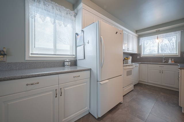 kitchen featuring sink, white appliances, white cabinets, decorative backsplash, and pendant lighting