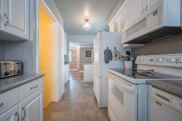 kitchen with white appliances, white cabinetry, and tasteful backsplash