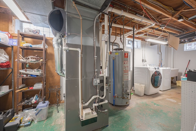 basement featuring plenty of natural light, gas water heater, heating unit, and washer and clothes dryer