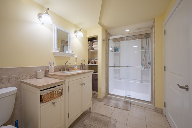 bathroom featuring tile patterned floors, toilet, vanity, and walk in shower