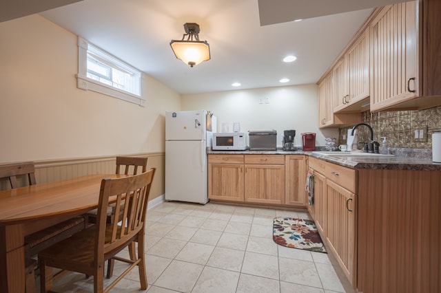 kitchen with white appliances, light tile patterned floors, sink, light brown cabinets, and tasteful backsplash