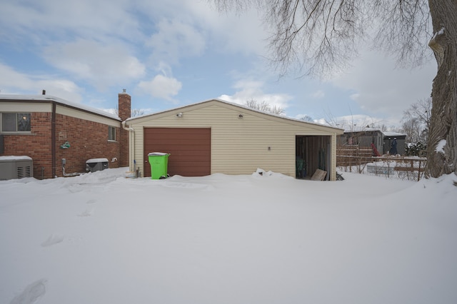 snow covered structure with a garage