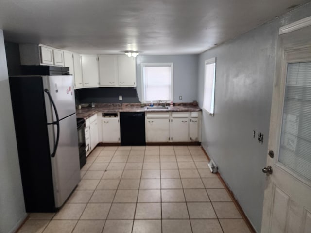 kitchen with white cabinets, dishwasher, light tile patterned floors, and stainless steel fridge