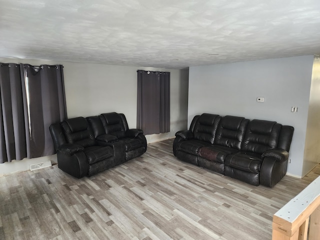 living room featuring a textured ceiling and light wood-type flooring