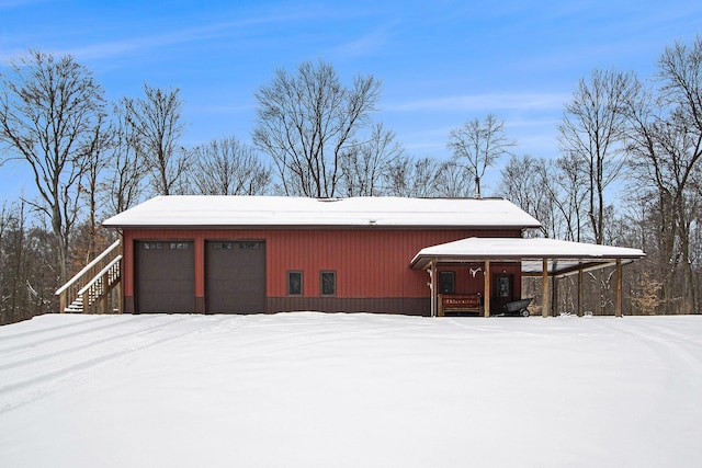 snow covered structure featuring a garage