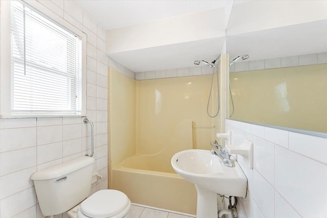 full bathroom featuring sink, toilet, tile walls, and shower / washtub combination