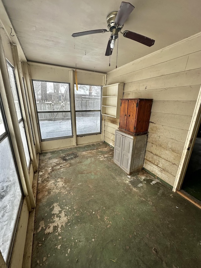 unfurnished sunroom featuring ceiling fan