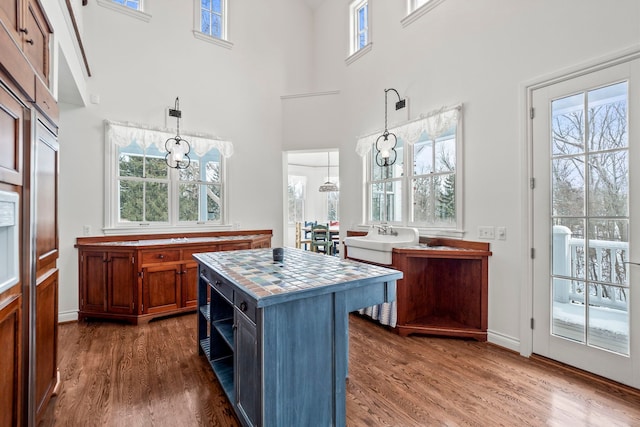 kitchen featuring sink, hanging light fixtures, dark hardwood / wood-style floors, a healthy amount of sunlight, and a kitchen island