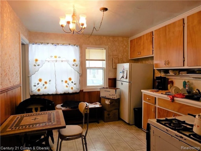 kitchen with pendant lighting, a chandelier, and white appliances