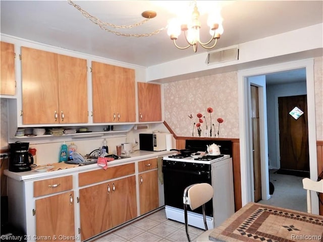 kitchen featuring range with gas stovetop and a notable chandelier