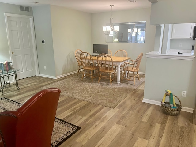 dining room with an inviting chandelier and light hardwood / wood-style floors