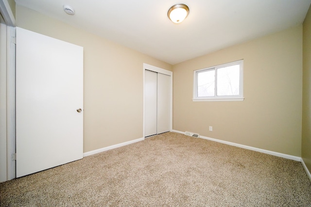 unfurnished bedroom with carpet floors and a closet