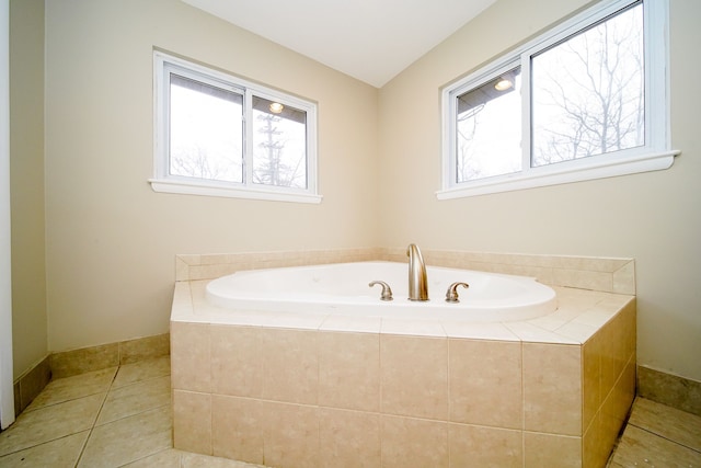 bathroom with tile patterned flooring and a relaxing tiled tub