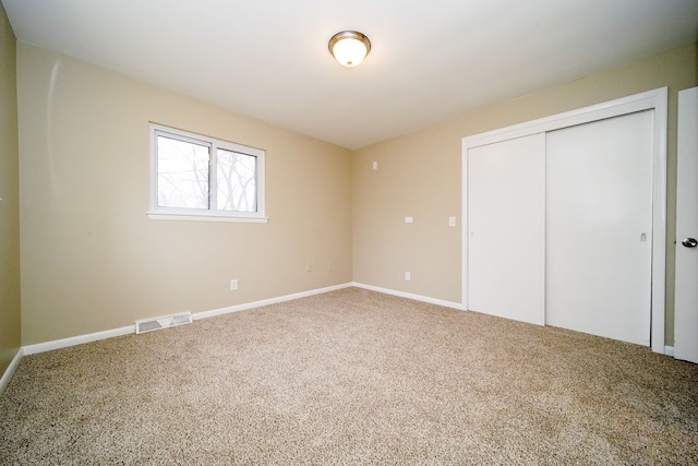 unfurnished bedroom featuring carpet and a closet