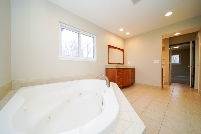 bathroom with vanity, tiled tub, and tile patterned flooring