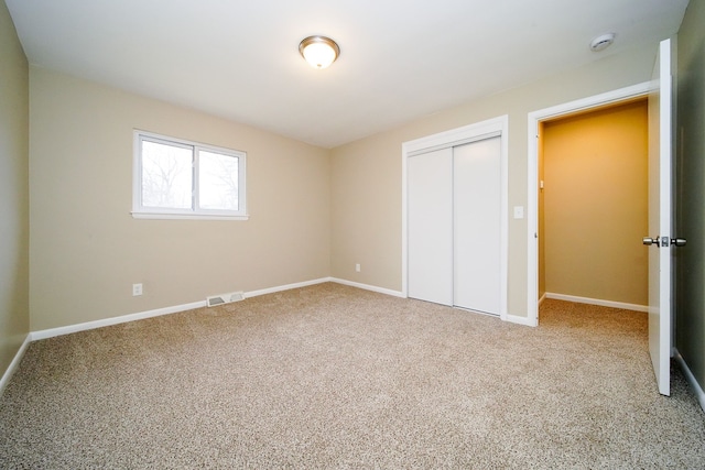 unfurnished bedroom with carpet flooring and a closet