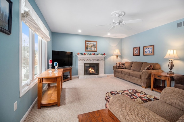 living room featuring ceiling fan, a fireplace, and carpet floors