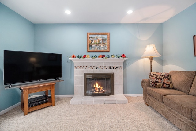 carpeted living room with a tile fireplace