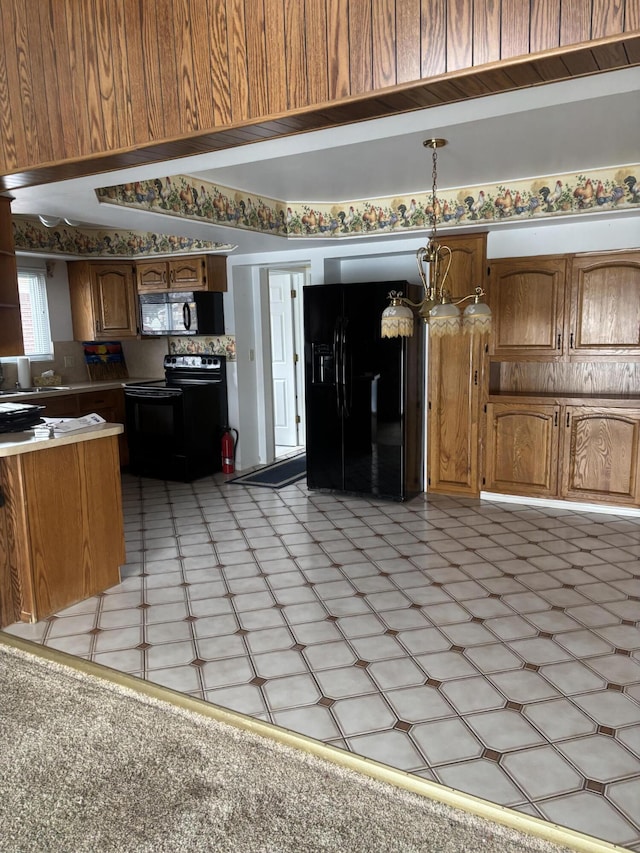 kitchen with an inviting chandelier, hanging light fixtures, black appliances, and sink