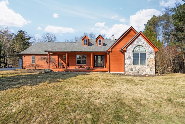 view of front of house featuring roof with shingles, a porch, a chimney, a front lawn, and stone siding