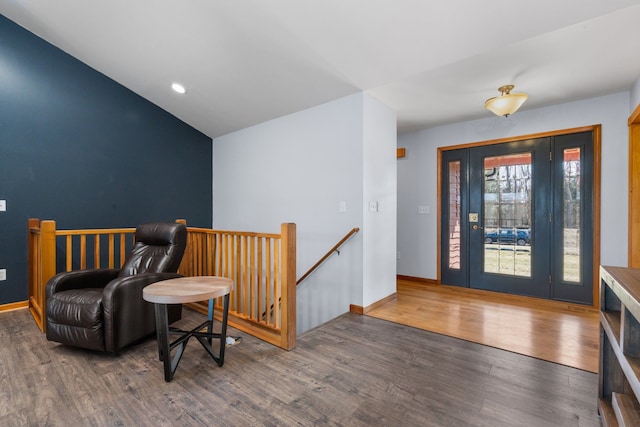 foyer entrance featuring vaulted ceiling, wood finished floors, and baseboards