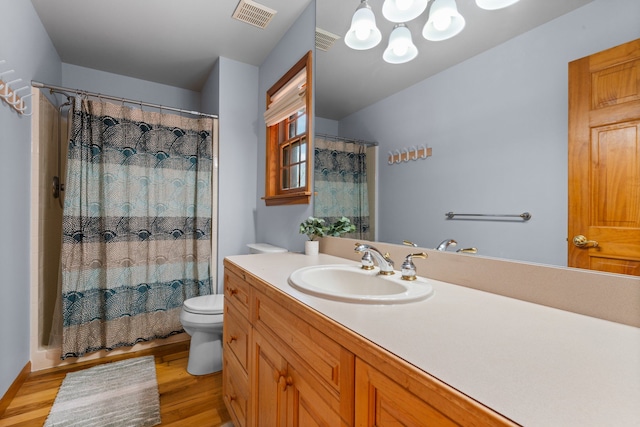 full bath with visible vents, toilet, vanity, and wood finished floors