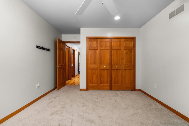 unfurnished bedroom with a ceiling fan, baseboards, visible vents, and light carpet