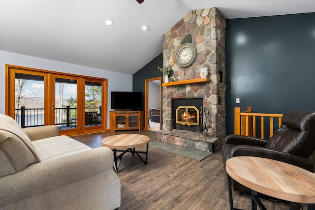 living area featuring vaulted ceiling, a stone fireplace, recessed lighting, and wood finished floors