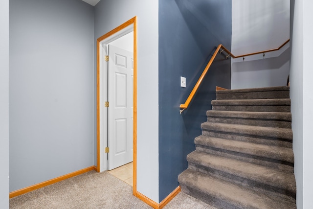 staircase with baseboards and carpet floors