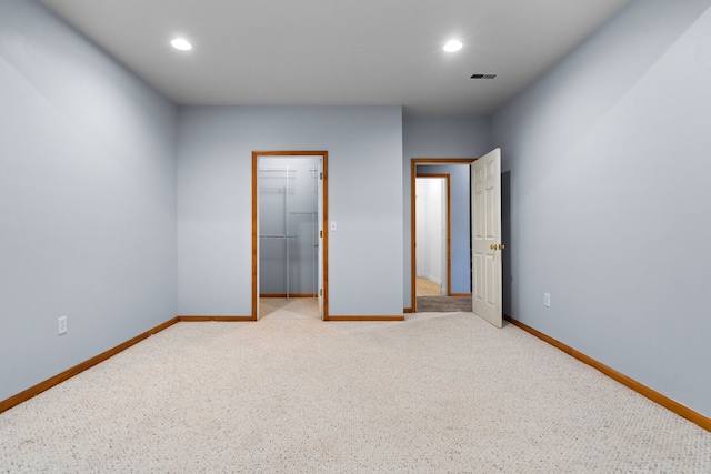 unfurnished bedroom featuring a spacious closet, recessed lighting, and baseboards