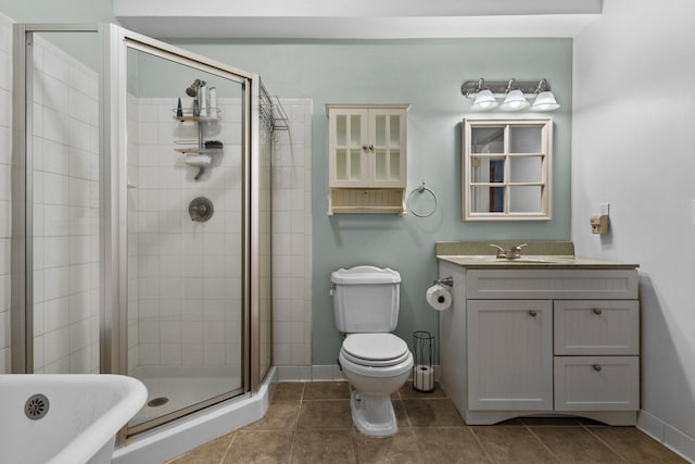 bathroom with a shower stall, baseboards, toilet, tile patterned floors, and vanity