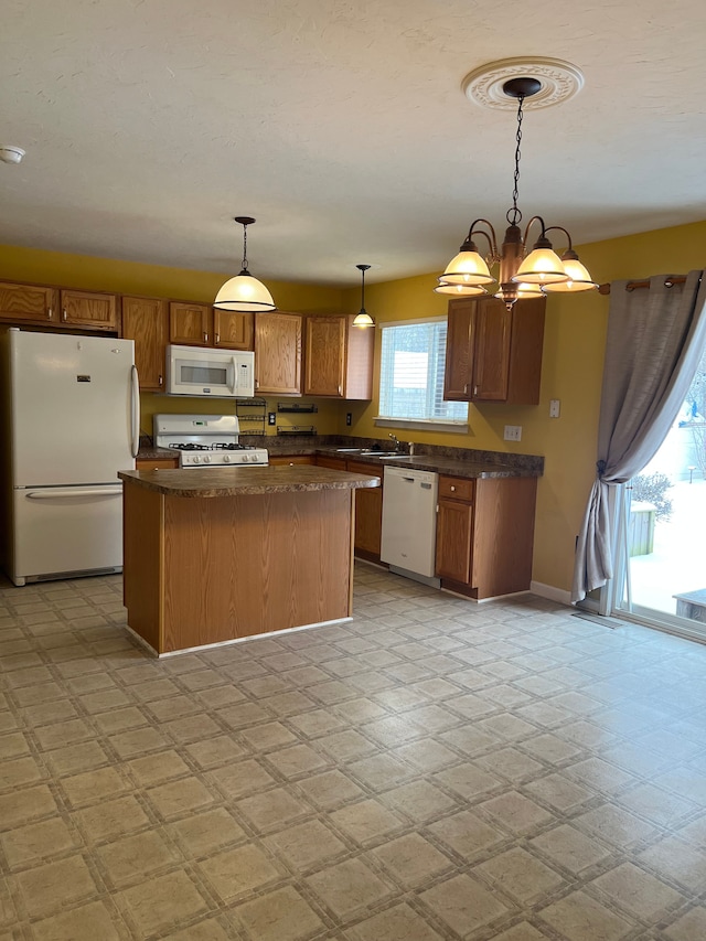 kitchen with pendant lighting, light floors, dark countertops, a kitchen island, and white appliances