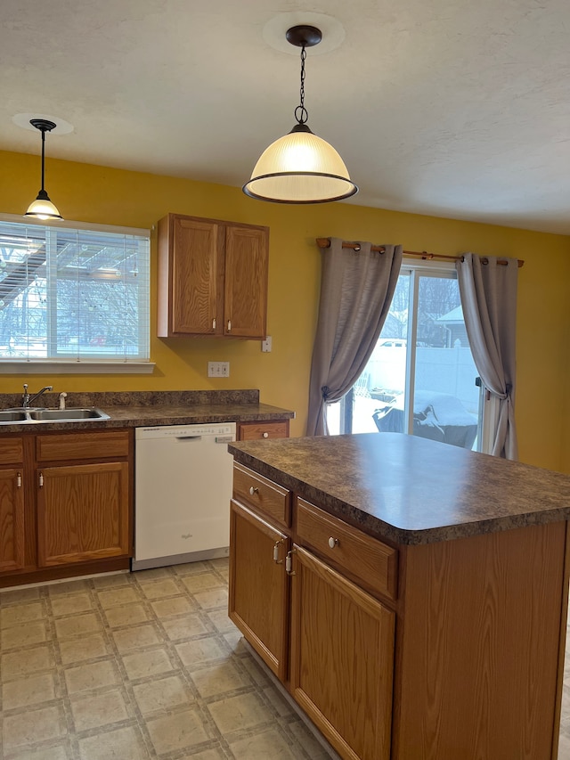 kitchen featuring pendant lighting, white dishwasher, a center island, and sink