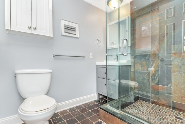 bathroom with toilet, a shower stall, vanity, baseboards, and tile patterned floors